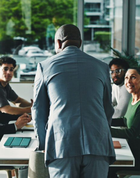 Man, presentation and group at office meeting, discussion and review with attention at finance company. Person, speaker and back with team, feedback and planning for strategy at investment agency
